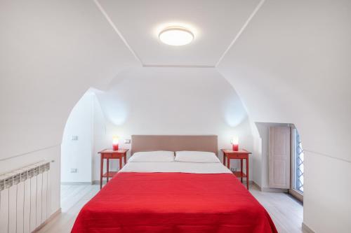 um quarto branco com uma cama vermelha e duas mesas em [Amalfi Coast]Elegant house in Penisola Sorrentina em Vico Equense
