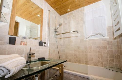 La salle de bains est pourvue d'un lavabo en verre et d'une douche. dans l'établissement Résidence Les Deux Chamois - 3 Pièces pour 4 Personnes 644, à Chamonix-Mont-Blanc