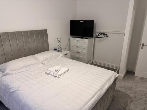 a bedroom with a bed with a flat screen tv at Stylish Lux in Morley