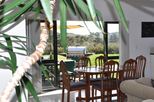 a dining room with a table and chairs on a patio at Okura River Estate Getaway in Auckland
