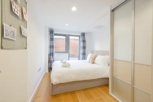 1 dormitorio con cama y espejo grande en Pass the Keys Modern Garden Flat - Steps from HI Upper Street en Londres