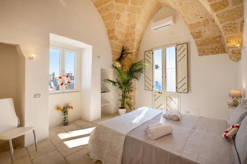 1 dormitorio con 1 cama grande en una habitación con ventanas en Charme Palace Salento, en Salice Salentino