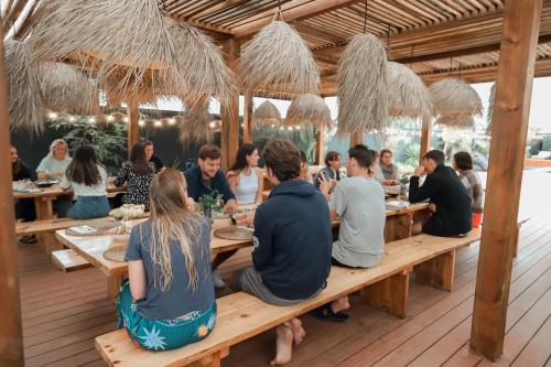 un gruppo di persone seduti a un tavolo in un ristorante di The Salty Pelican Yoga & Surf Retreat a Peniche