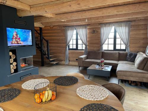 a living room with a couch and a table at BearHouse Chalet in Poiana Mărului