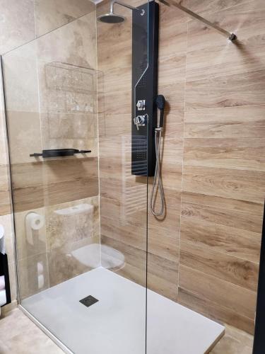 una ducha con una puerta de cristal y un teléfono. en Mas bellevue, en Boulbon