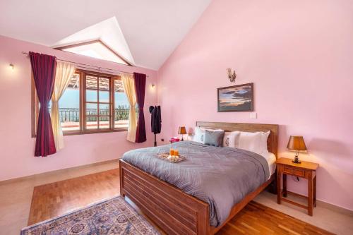 a bedroom with a large bed and a window at StayVista at The West Wind in Ooty