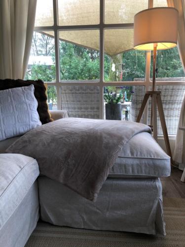 uma cama num quarto com uma grande janela em Chalet 2Relax em Zutendaal