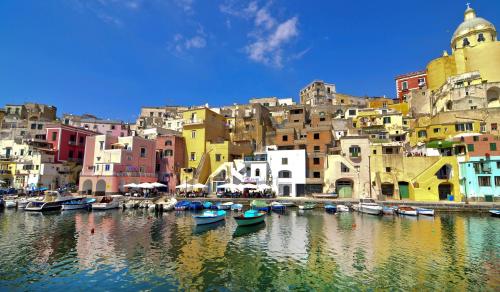 a group of boats in a body of water with buildings at Palazzo Palumbo in Procida