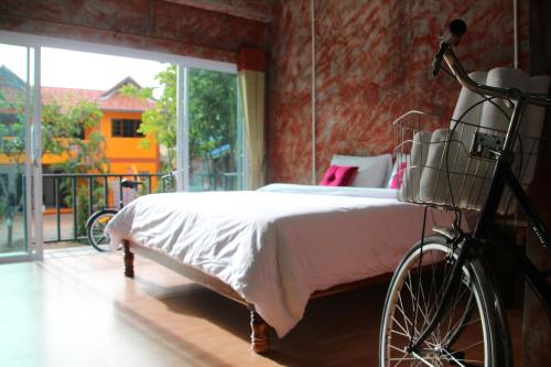 una camera da letto con una bicicletta parcheggiata accanto a un letto di Samui Poshtel a Chaweng Beach