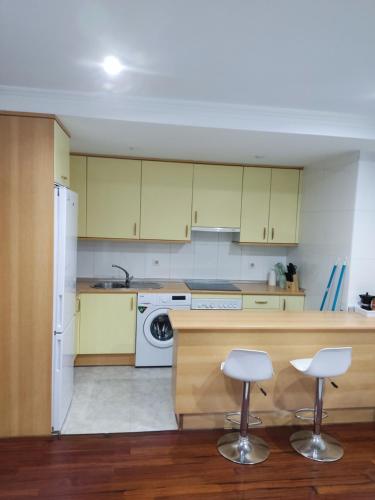 eine Küche mit gelben Schränken und weißen Geräten in der Unterkunft Centrico y acogedor, Posibilidad parking 10 euros dia in Vigo