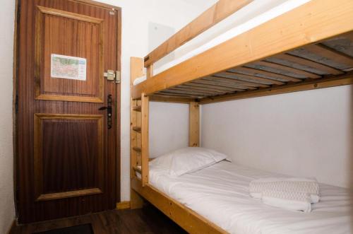 1 Schlafzimmer mit 2 Etagenbetten und einer Tür in der Unterkunft Résidence Clos Du Savoy - Studio pour 4 Personnes 964 in Chamonix-Mont-Blanc
