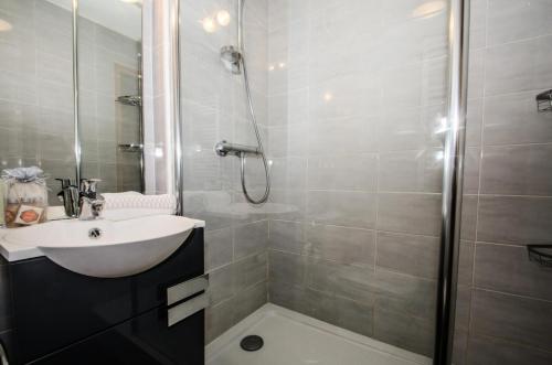 ein Bad mit einem Waschbecken und einer Dusche in der Unterkunft Résidence Clos Du Savoy - Studio pour 4 Personnes 964 in Chamonix-Mont-Blanc