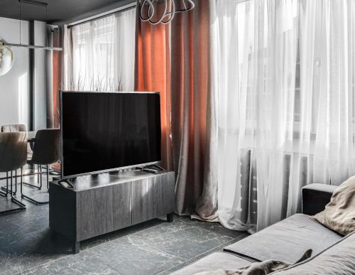 a living room with a flat screen tv on a cabinet at BLACKNIGHT Apartment - Self Check-In 24h in Wrocław