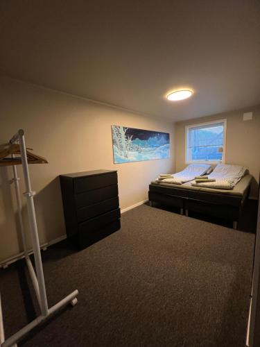 a small bedroom with a bed and a window at Your home away from home, apartment 1 in Tromsø