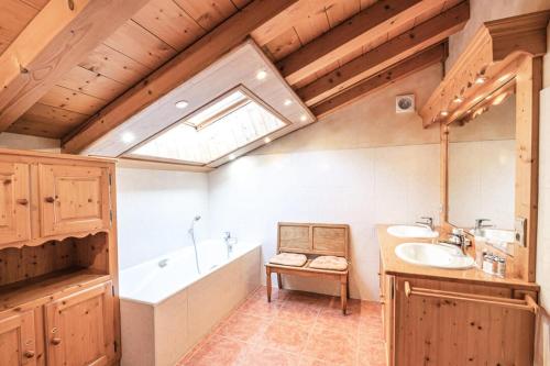 baño con 2 lavabos, bañera y ventana en Résidence Perseverance - Chalets pour 12 Personnes 054 en Chamonix-Mont-Blanc