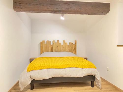 une chambre avec un lit avec une tête de lit en bois dans l'établissement Maison Alsacienne & Moderne en Hypercentre, à Colmar
