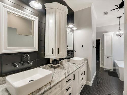 ein weißes Badezimmer mit einem Waschbecken und einem Spiegel in der Unterkunft Clearview Castle - Pool* Jacuzzi Lake View in Lewisville