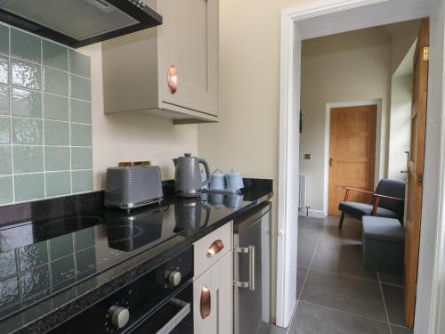 a kitchen with a black counter top in a room at The Stables in Denbigh