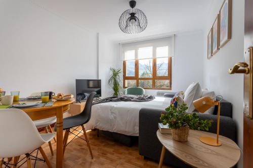 a bedroom with a bed and a desk and a table at Apartamento Balcón de Liérganes in Liérganes