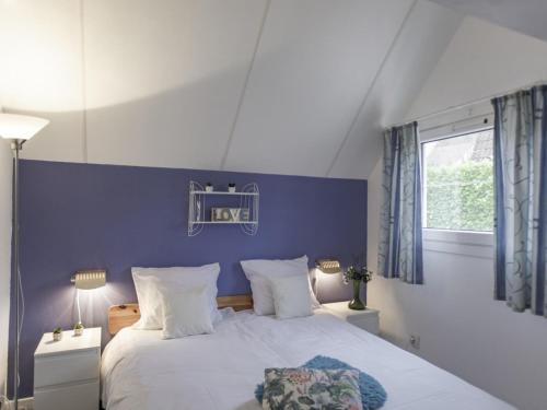 a bedroom with a large bed with a blue wall at Villa Campagne 138 in Daumazan-sur-Arize