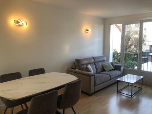 un salon avec un canapé et une table dans l'établissement Beautiful and quiet 1 bedroom 10min from Paris, à Colombes