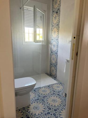 a bathroom with a toilet and a window at Casa Caraza. Un olivar con vistas al castillo de Juego de Tronos in Almodóvar del Río