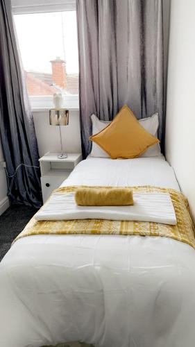 ein Schlafzimmer mit einem großen weißen Bett und gelben Kissen in der Unterkunft Herbert - MexTown Contractors in Mexborough