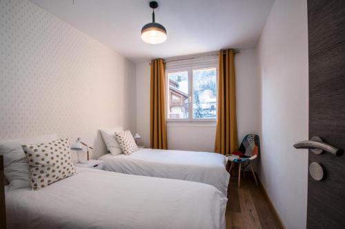 Cette petite chambre comprend 2 lits et une fenêtre. dans l'établissement Résidence Panoramic - 3 Pièces pour 6 Personnes 194, à Chamonix-Mont-Blanc