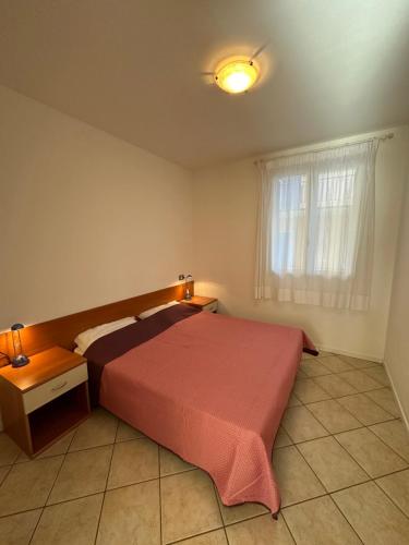 a bedroom with a large bed and a window at RESIDENCE STEFANIA Appartamenti piano terra - AGENZIA COCAL in Caorle