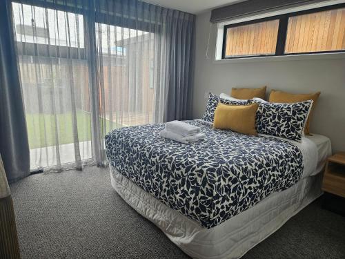 a bedroom with a bed and a large window at The Totara Bach in Twizel