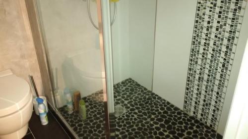 La salle de bains est pourvue d'une douche et de carrelage noir. dans l'établissement 3 Pièces Résidence avec Piscine 100m Plages 125, à Cavalaire-sur-Mer