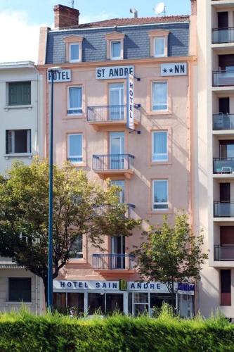 a tall building with street signs in front of it at Hôtel Saint André Gare SNCF in Clermont-Ferrand