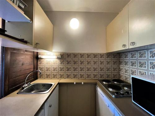 une petite cuisine avec un évier et une cuisinière dans l'établissement Résidence Genepi - Studio 4 personnes avec vue sur la montagne MAE-4954, aux Menuires