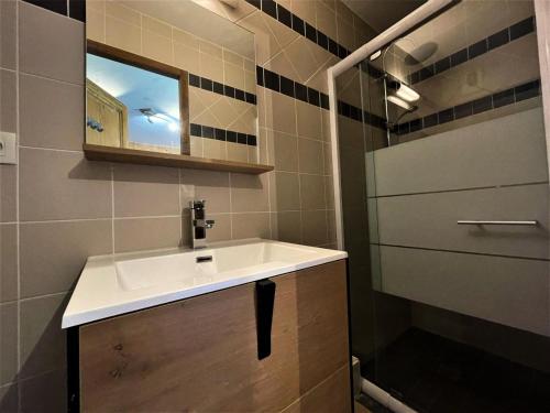 a bathroom with a sink and a mirror at Résidence Geffriand - Pièces 944 in Levassaix