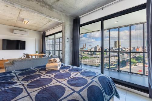 a bedroom with a bed and a large window at Loft Elegante a 5 Minutos de Puerto Madero 8A in Buenos Aires