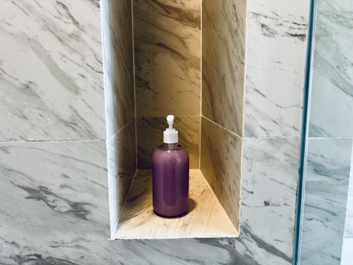 une bouteille violette dans une boîte dans une salle de bain dans l'établissement Imperio Residence Melaka by Dream View, à Malacca