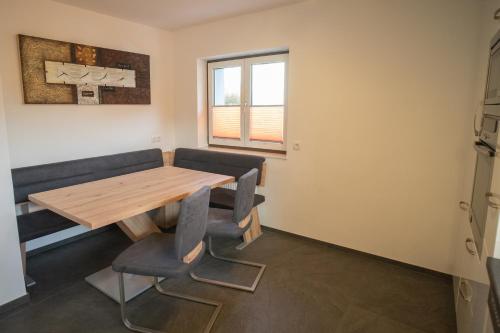 a dining room with a wooden table and chairs at Ferienwohnug Weissl in Matrei am Brenner