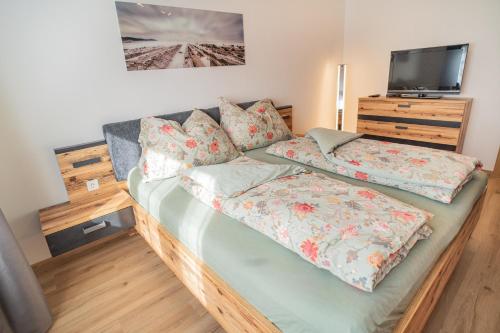 ein Schlafzimmer mit einem Bett und einem TV auf einem Tisch in der Unterkunft Ferienwohnug Weissl in Matrei am Brenner