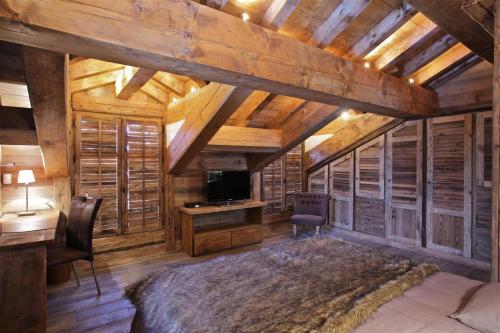 a bedroom in a cabin with a desk and a television at Résidence Ajacour - Chalets pour 8 Personnes 034 in Courchevel