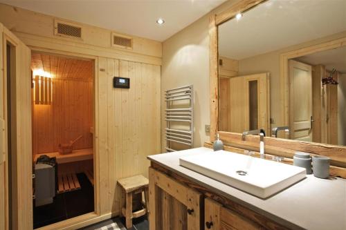 a bathroom with a sink and a large mirror at Résidence Ajacour - Chalets pour 8 Personnes 034 in Courchevel
