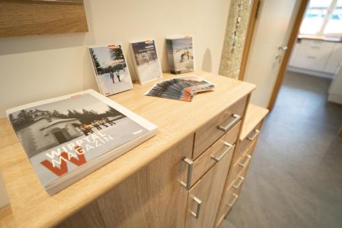 a wooden counter with pictures and a book on it at Ferienwohnug Weissl in Matrei am Brenner