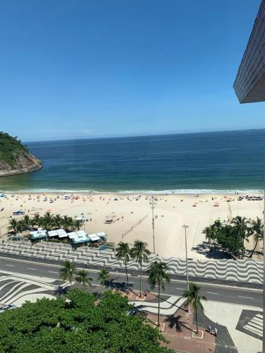 uma praia com muita gente e o oceano em suite deluxe vista mar Copacabana - entrada independente no Rio de Janeiro