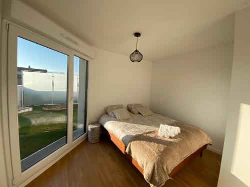 um quarto com uma cama e uma grande janela em Le 147 Parc Entre Paris et Disney em Champigny-sur-Marne