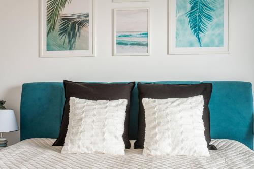 a bedroom with a blue couch with two pillows at Seaview Plaza in Dziwnów
