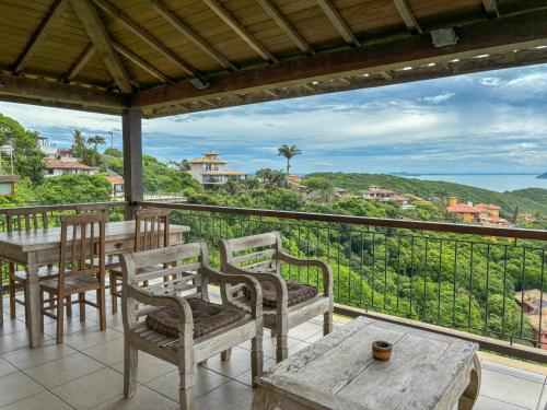 a balcony with tables and chairs and a view of the ocean at Pousada La Belle Maison Brigitte Bardot in Búzios