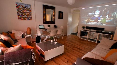 a living room with a couch and a dining room at 3-Bed House with Amazing Garden in London