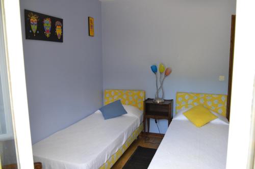 - une chambre avec 2 lits et une table avec un vase dans l'établissement Le Hêtre Pourpre, à Carcagny