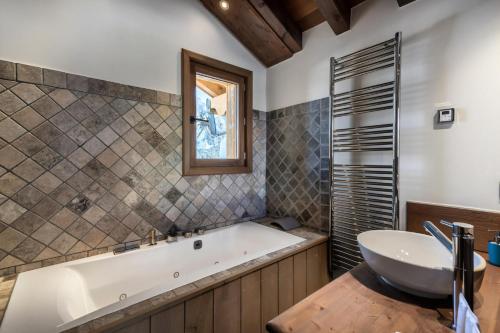 a bathroom with a tub and a sink at Résidence Prosper - Chalets pour 12 Personnes 154 in Courchevel