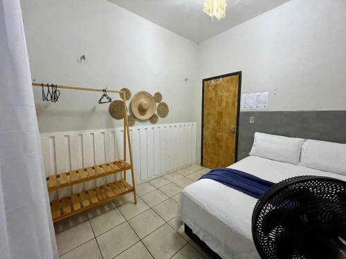 Un dormitorio con una cama y un sombrero en la pared en Mini Hostel, en Tutóia