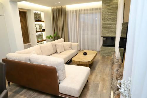 a living room with a white couch and a fireplace at Green Villa with Private Pool in Durrës